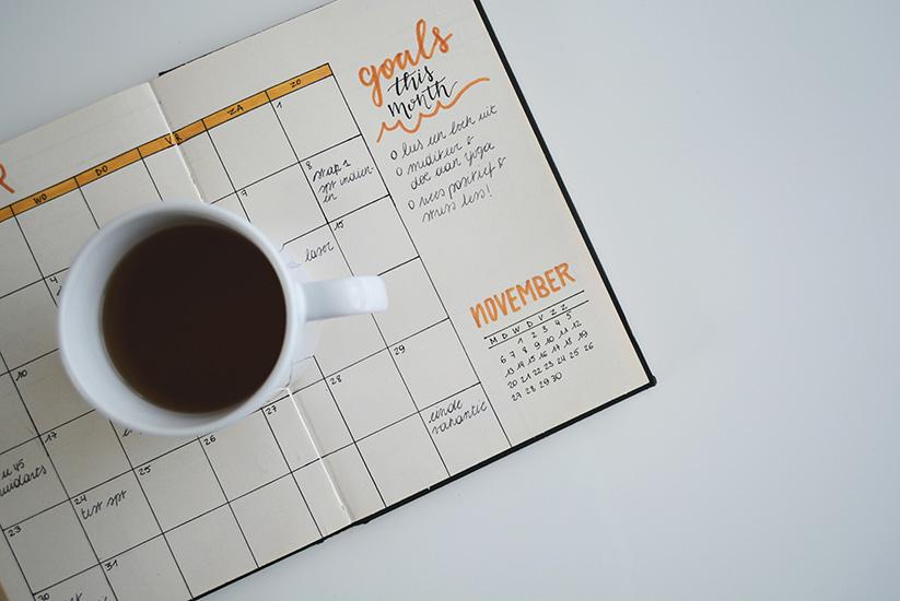 Een kalender van de maand november met een tas koffie op.